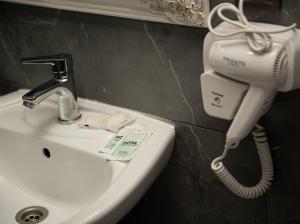a bathroom sink with a phone on the wall at AMSTERDAM hotel&swimming pool in Suprunovka