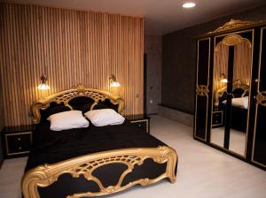 a bedroom with a large bed and a large mirror at AMSTERDAM hotel&swimming pool in Suprunovka