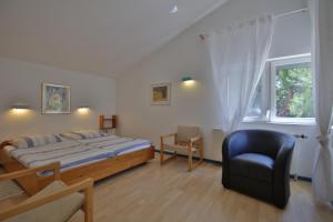 a bedroom with a bed and a chair and a window at Villa A in Pirovac