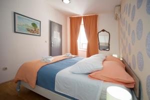 1 dormitorio con 1 cama con manta naranja y azul en Split Ann Apartments, en Split