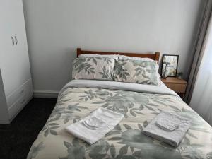 a bedroom with a bed with two towels on it at Sun-kissed house in Auckland