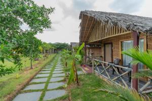 a house with a stone path next to a building at Hampi Natures Cottage in New Hampi
