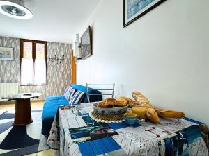 a table with bread and a plate of food on it at Côté Mer - Appartement Chaleureux & Cosy - Déco Bord de Mer - Centre-Ville Rue Commerçante - Smart TV Netflix & WiFi Fibre - Cuisine Équipée & Nespresso - Check-in Autonome - Parking Facile à Proximité - Confort & Sérénité in Sens