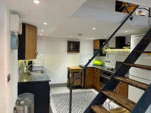 a kitchen with a staircase leading up to a kitchen at Jack's House in Hastings
