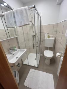łazienka z prysznicem, toaletą i umywalką w obiekcie Gästehaus Lindermuth w mieście Presseggersee +23 zdjęcia