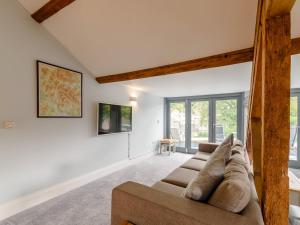 a living room with a brown couch in a room with windows at Cragdale Penthouse in Settle