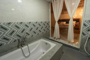 a bathroom with a bath tub with a shower at Hampi Natures Cottage in New Hampi +109 photos