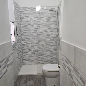 a bathroom with a toilet and a brick wall at TinaToni Apartment in Follonica +12 photos