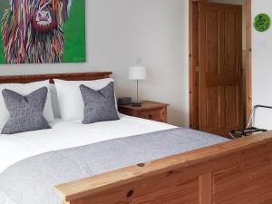 Schlafzimmer mit einem Bett mit Löwengemälde an der Wand in der Unterkunft Roe Deer Cottage in North Ballachulish