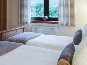ein Schlafzimmer mit zwei Betten und einem Fenster in der Unterkunft Roe Deer Cottage in North Ballachulish