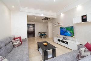 a living room with a couch and a tv on a wall at Mamounia Horizon in Casablanca
