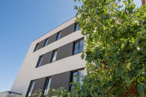 an office building with windows and a tree at Samstag ParkZone in Split
