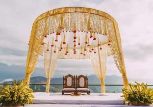 a gold wedding arch with two beds on a table at Hotel Om Palace Mcleodganj Himachal Pradesh in Dharamshala