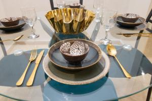 a glass table with bowls and utensils on it at Mamounia Horizon in Casablanca