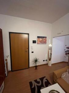 a living room with a brown door and a couch at Dream's Tower BO in Bologna