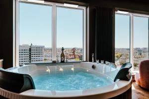 a hot tub in a room with windows at Quorum River SPA Sauna&Jacuzzi or Sauna&Terrace Centrum in Wrocław