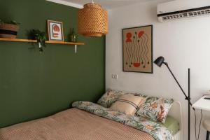 a green bedroom with a bed and a lamp at Dotan's Boutique Studios - By The Beach! in Tel Aviv