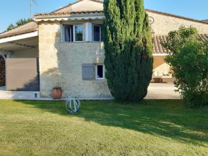 a house with a large tree in the yard at Sérénité in Saint-Genès-de-Castillon