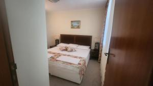 a small bedroom with a bed and a door open at Apartment Sunset resort C8-24 in Pomorie