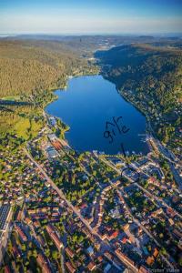 an aerial view of a city and a lake at Le Meix du Lac 3 étoiles - 200 m du lac - 50 m navette ski in Gérardmer +8 photos
