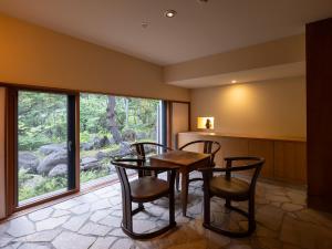ein Esszimmer mit Tisch und Stühlen und einem Fenster in der Unterkunft 小樽旅亭 蔵群 in Otaru
