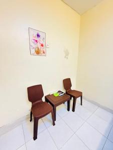 Dos sillas y una mesa en una habitación. en Homestay Room near Kuta & Legian Beach Bali, en Pesanggaran
