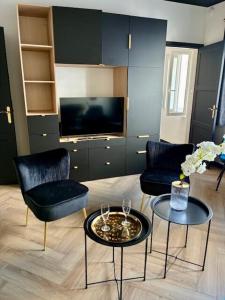 a living room with two chairs and a table and a tv at Coeur De Plage - Studio Royan Hyper Centre - Classé 3 étoiles - 2 pers - 150m plage in Royan +19 photos