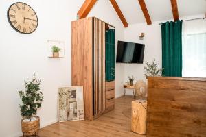 a living room with a television and a clock on the wall at Casa Olive in Šibenik