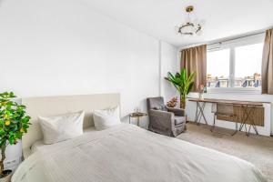een witte slaapkamer met een groot bed en een bureau bij Suite Vue Tour Eiffel in Parijs