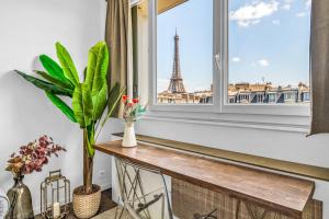 een kamer met een raam met de Eiffeltoren bij Suite Vue Tour Eiffel in Parijs