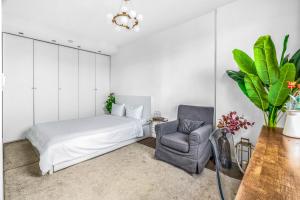 een slaapkamer met een bed en een stoel bij Suite Vue Tour Eiffel in Parijs