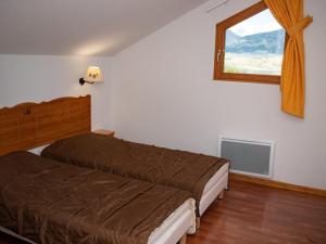 a bedroom with two beds and a window at Appartement Duplex 3 Pièces avec Piscine Chauffée à 300m des Pistes - Superdevoluy - FR-1-504-457 in Superdevoluy