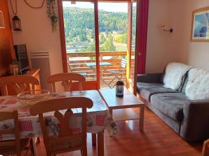 a living room with a couch and a table at Duplex 4 pers avec balcon, piscine couverte, proche pistes – Superdévoluy - FR-1-504-570 in Superdevoluy