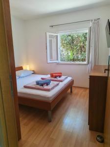 una camera da letto con un letto e una finestra di Rogoznica Seafront Apartment - Kalebova Luka a Rogoznica (Rogosnizza) Altre 35 foto