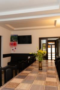 a long table with chairs and a vase of flowers at Pensiunea Bucur in Dămuc