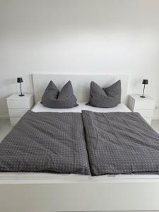 a white bed with gray pillows on top of it at Wohnung in Dahme