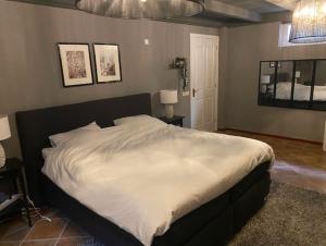 a bedroom with a large bed with white sheets at De Reesterhoeve in Balkbrug +28 photos