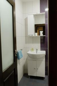 a white bathroom with a sink and a mirror at Pensiunea Bucur in Dămuc +48 photos