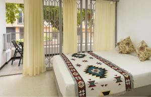 a bedroom with a bed and a balcony at Loft cerca a Laureles, WIFI, cerca metro, con Balcón, GUARDA MALETAS GRATIS!! in Medellín