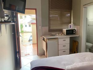 a small kitchen with a microwave on a counter at Emampingeni lodge in Bizana