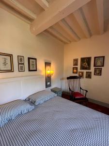 a bedroom with a bed and a chair at La sosta al lago in Londa