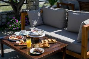 a table with plates of food and drinks on it at Vickys Rooms - Faliraki in Faliraki