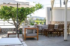 a patio with a table and chairs and an umbrella at Vickys Rooms - Faliraki in Faliraki