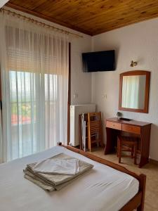 a bedroom with a bed and a desk and a mirror at Ψητοπωλείο Καφέ Ενοικιαζόμενα Δωμάτια Όλυμπος in Pétra +11 photos