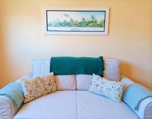 a white couch with pillows sitting under a picture at Miramar 2 - San Sebastin de La Gomera in San Sebastián de la Gomera