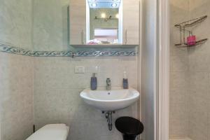 une salle de bains avec lavabo, toilettes et miroir dans l'établissement Appartamento Lily, à Florence 15 autres photos