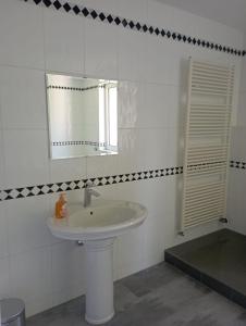 a white bathroom with a sink and a mirror at Monteurwohnung Monti 2 in Saarbrücken
