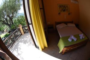 a small bedroom with a bed and a balcony at Yannis' Village in Keri