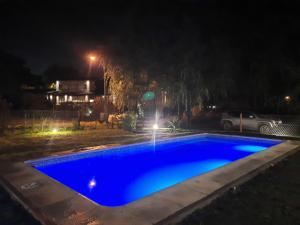 a blue swimming pool with a fountain at night at Casa Lavanda in Sierra de los Padres +6 photos