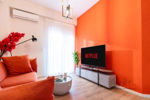 an orange living room with a television on a table at Duplex in Piraeus' Best Street 2Bath w-FreeParking in Piraeus